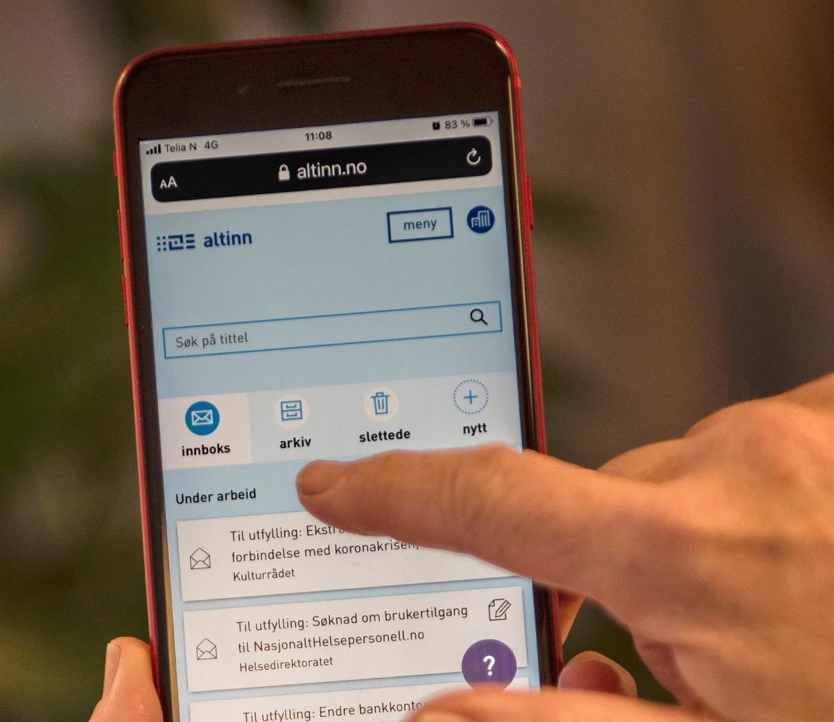 Mobile phone with the Altinn website. The web page shows forms for applications related to the coronavirus  pandemic.