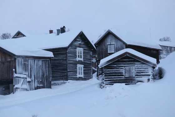 Gamle tømmerbygninger på Røros etter en vinterstorm.