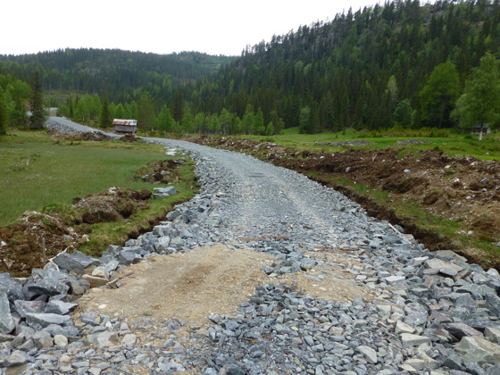 Skogsbilvei med forsterkingslag og bærelag av sprengt fjell fra pall ved enden av veien. Slomstaulvegen, Kviteseid.