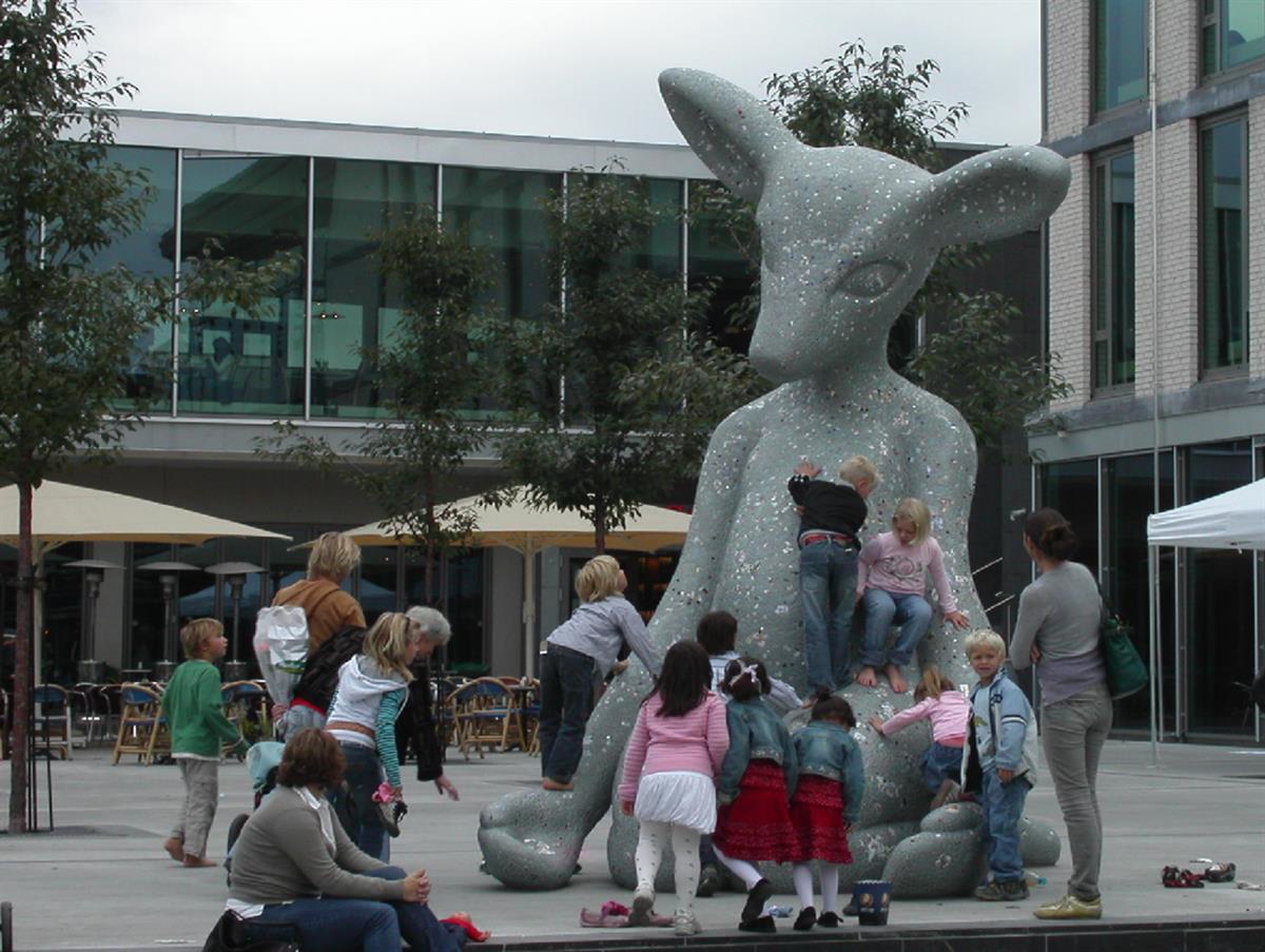 Barn som klatrer på kengurulignende skulptur.