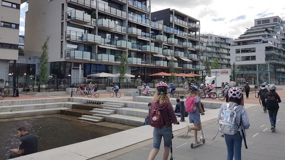 Barn på sparkesykkel på Union brygge med nye boliger, næring og møteplasser