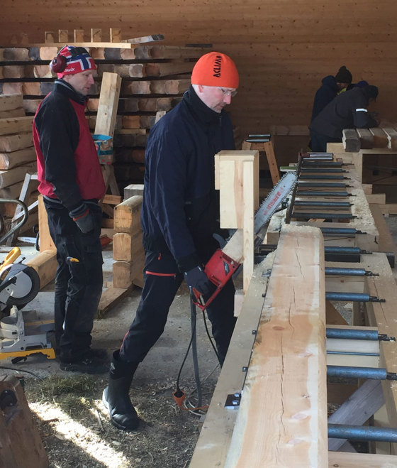 Ritman kapper en laftestokk i riktig lengde på den sjølkonstruerte arbeidsbenken. 