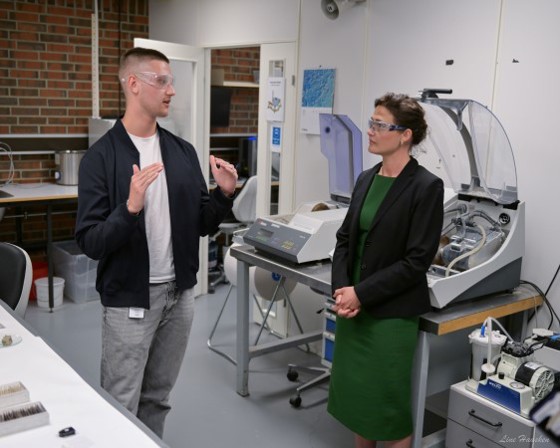 Laboratorielærling Olaf Cezary Normann  og statsråd Kari Nessa Nordtun er i en lab, og har på seg vernebriller. 