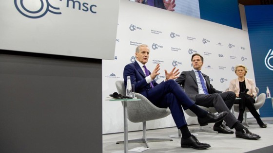 Støre på scenen i München sammen med Rutte og von der Leyen.