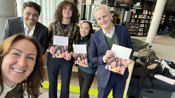 Arbeids- og inkluderingsminister Tonje Brenna (Ap)  tar selfie med Statsminister Jonas Gahr Støre (Ap), Betina Belegu (t.v) og Nilofar Nori (t.h)  fra IMDis ungdomspanel  og advokat Servet Yildiz Stêrk. De holder handlingsplanen og ser i kameraet mens de smiler