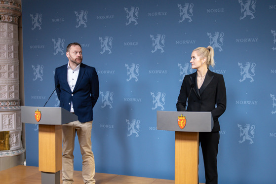 Utvalgsleder på et podium sammen med justis- og beredskapsminister Emilie Enger Mehl.