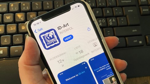 Hånd som holder mobil med ID-art-appen oppe.