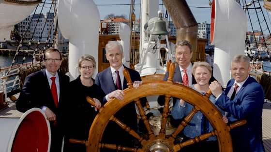 Statsministeren står sammen med fem statsråder ved roret på Statsraad Lehmkuhl.