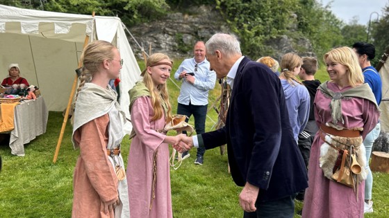 Statsministeren hilser på utkledde kvinner på Moster.