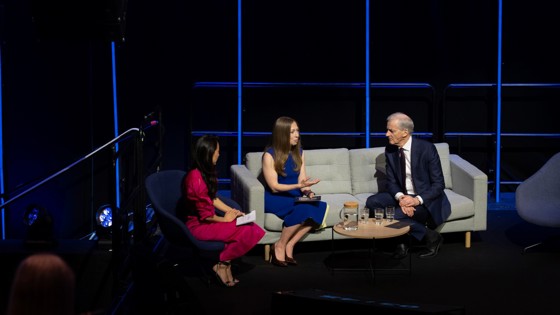 Statsministeren sitter i en sofa på scenen i Oslo Spektrum, sammen med Chelsea Clinton.