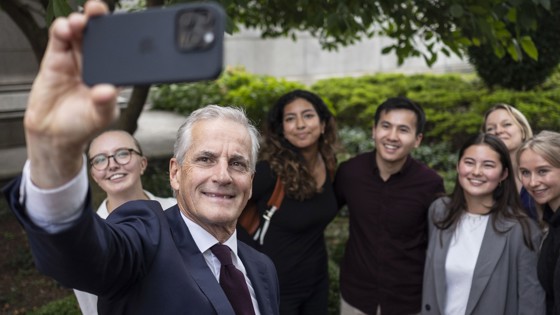 Bilde av Støre som tar selfie med seks studenter