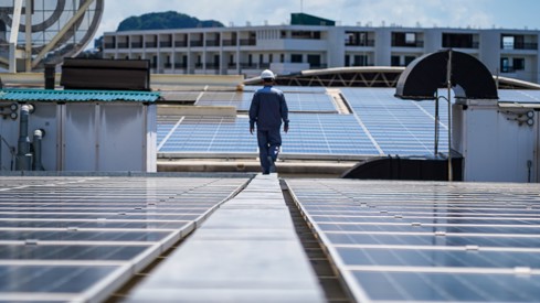 Bilde av en mann som går på et tak med solceller